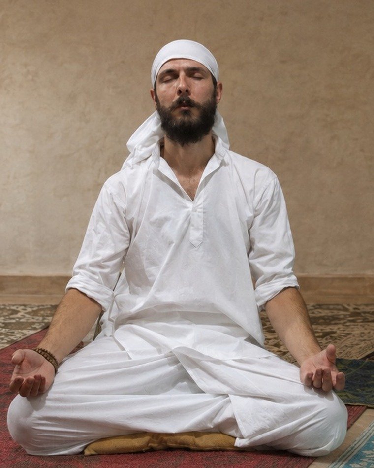 Jayakrishna-ji assis en méditation en intérieur.