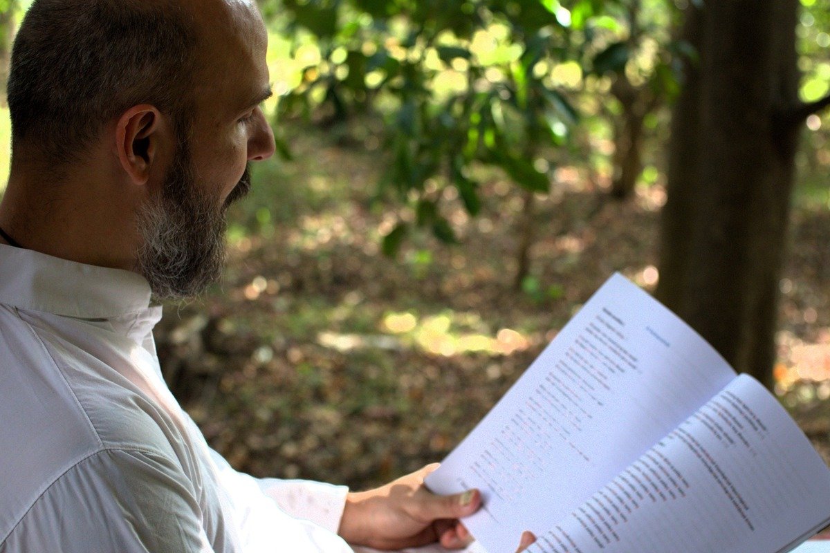Jayakrishna-ji lisant un texte en extérieur.
